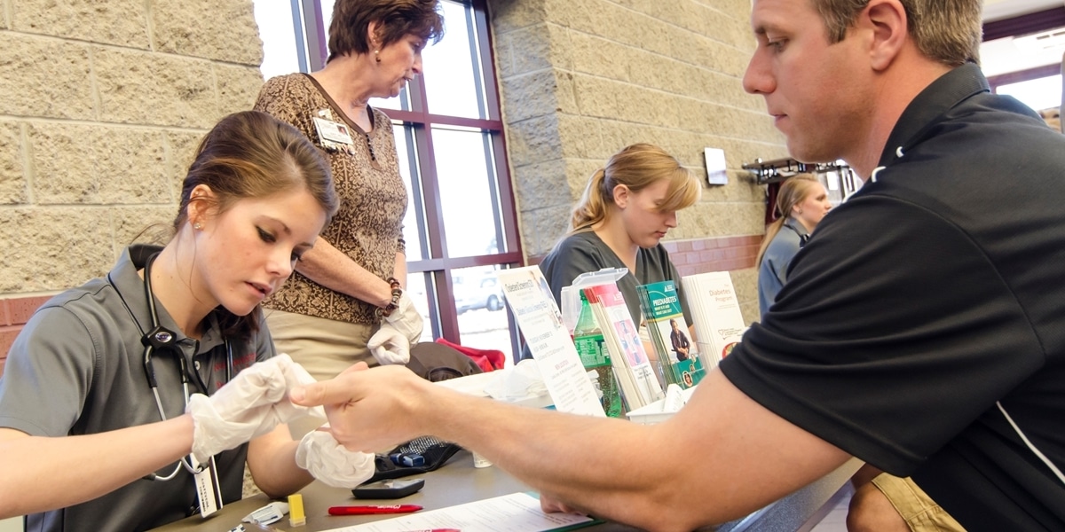 A Northwestern nursing student administers a shot to a patient.
