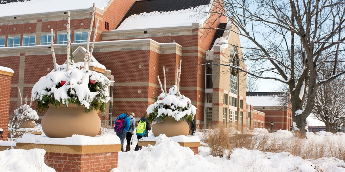Students walk across a snow-covered campus.
