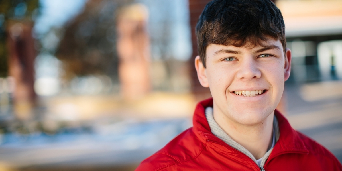 A posed student smiles at the camera.
