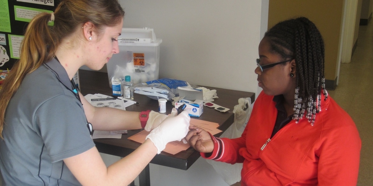 A Northwestern nursing student administers a shot to a patient.