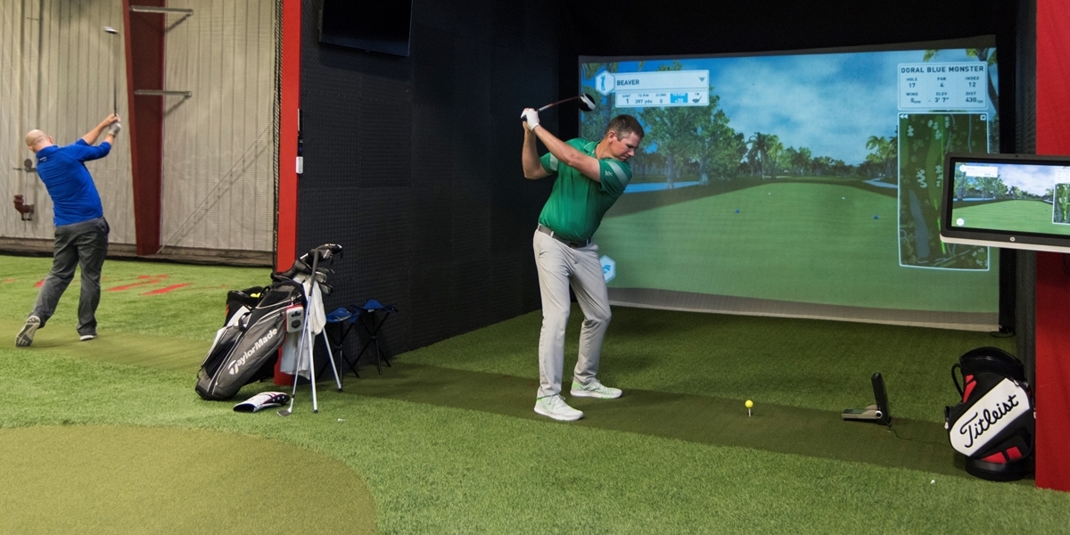 A Northwestern student practices his swing using the golf simulator in the Juffer Athletic Fieldhouse.