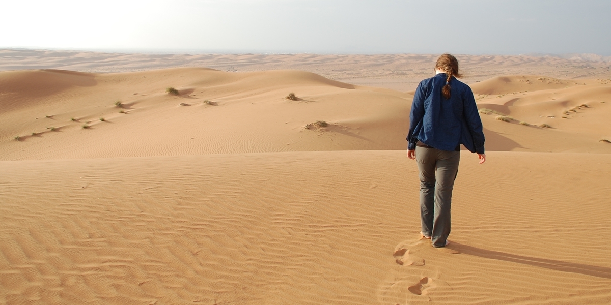 A Northwestern student walks in the desert during her semester in Oman.