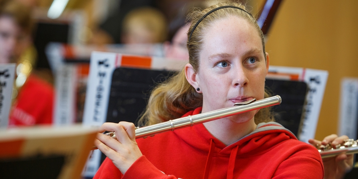 A flutist practices with the rest of the Symphonic Band during class.