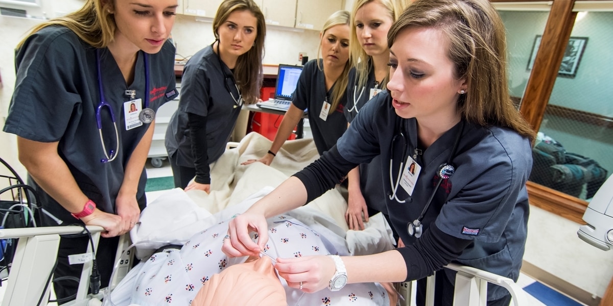 Northwestern nursing students administer medication to a patient simulator.