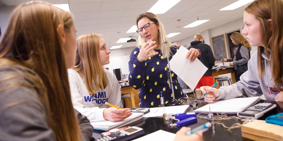 Students and professor in physics lab