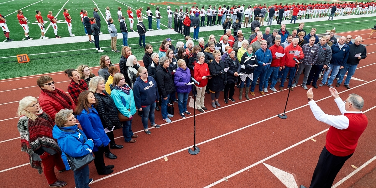 An alumni choir sings at Homecoming.