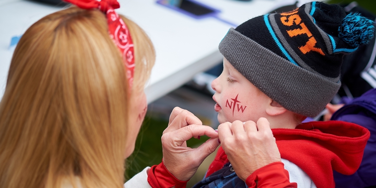 A child gets his face painted with the Northwestern logo during Morning on the Green.