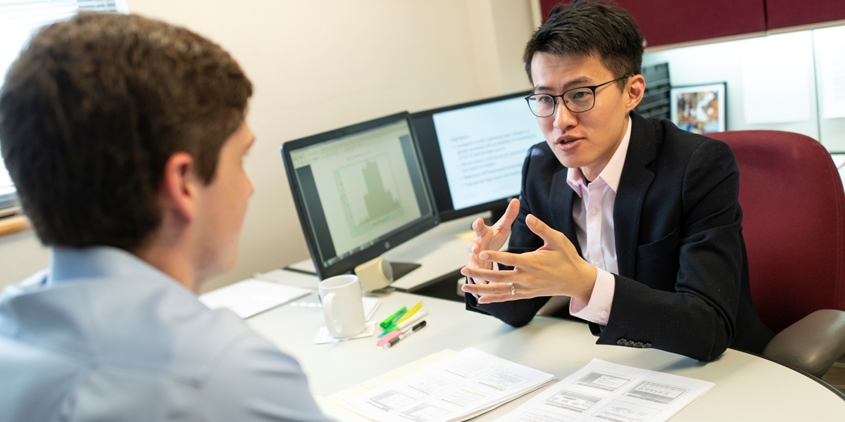 Business professor Han-Yen Kao meets with a student in his office.
