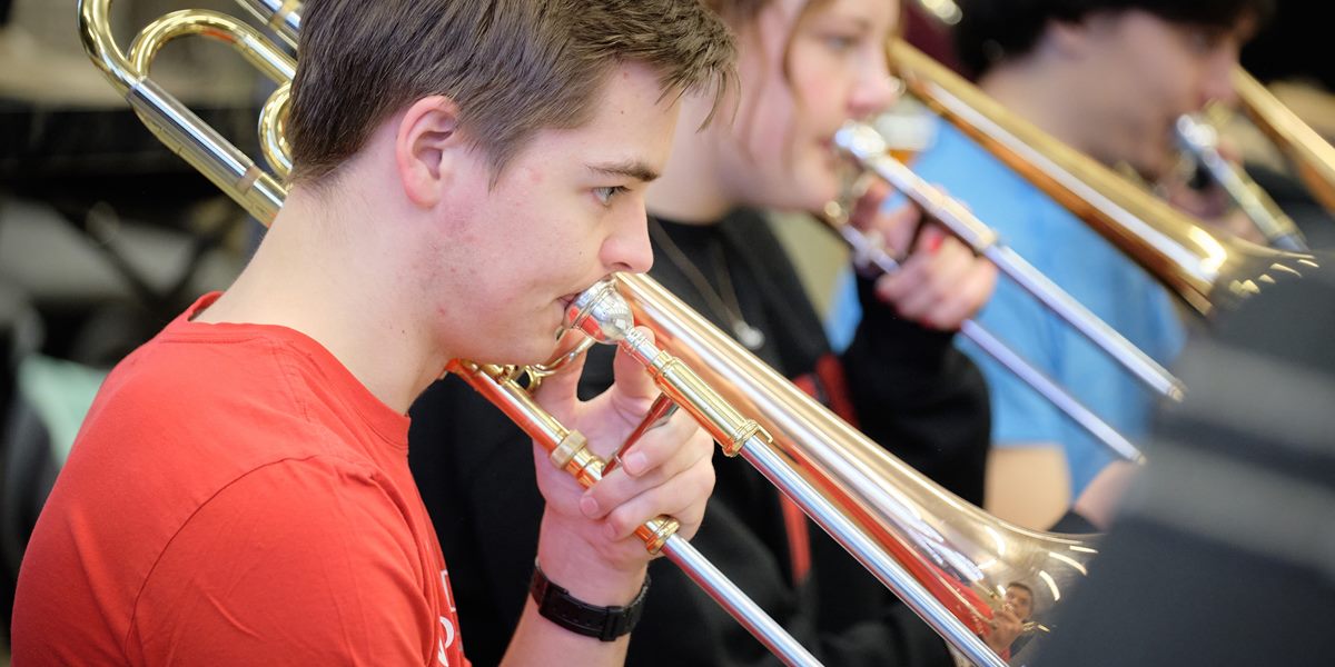 Trombonists rehearse in the band room.