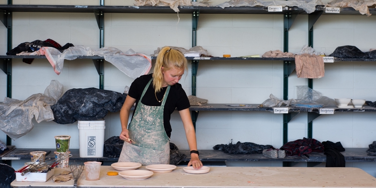 A Northwestern student checks on her clay projects.