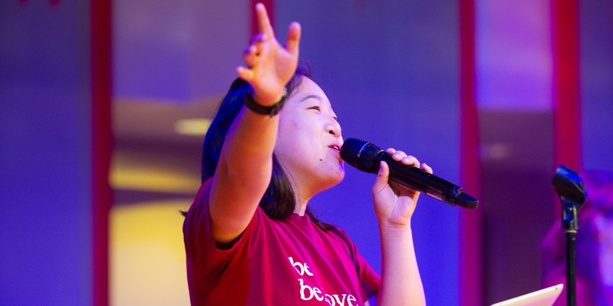 A student leads music during a chapel service.