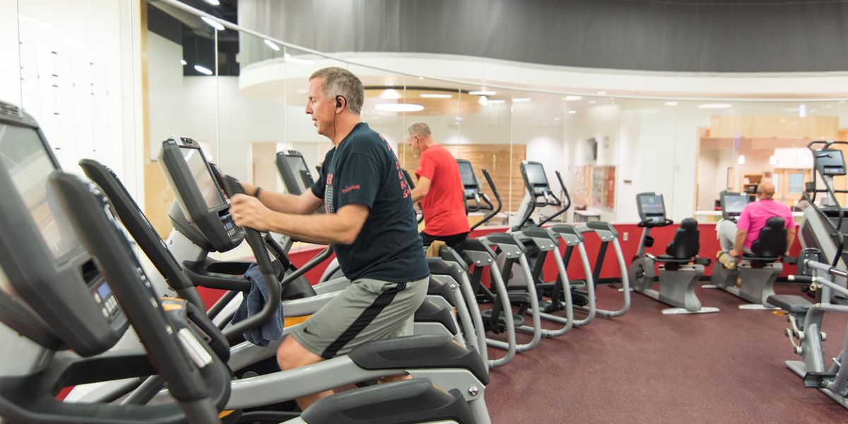 A community member exercises on an elliptical in the DeWitt Fitness Center.