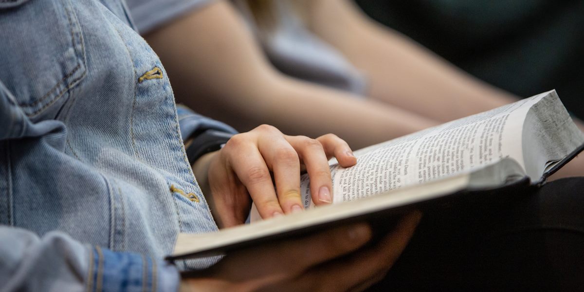 A student reads a Bible during chapel.