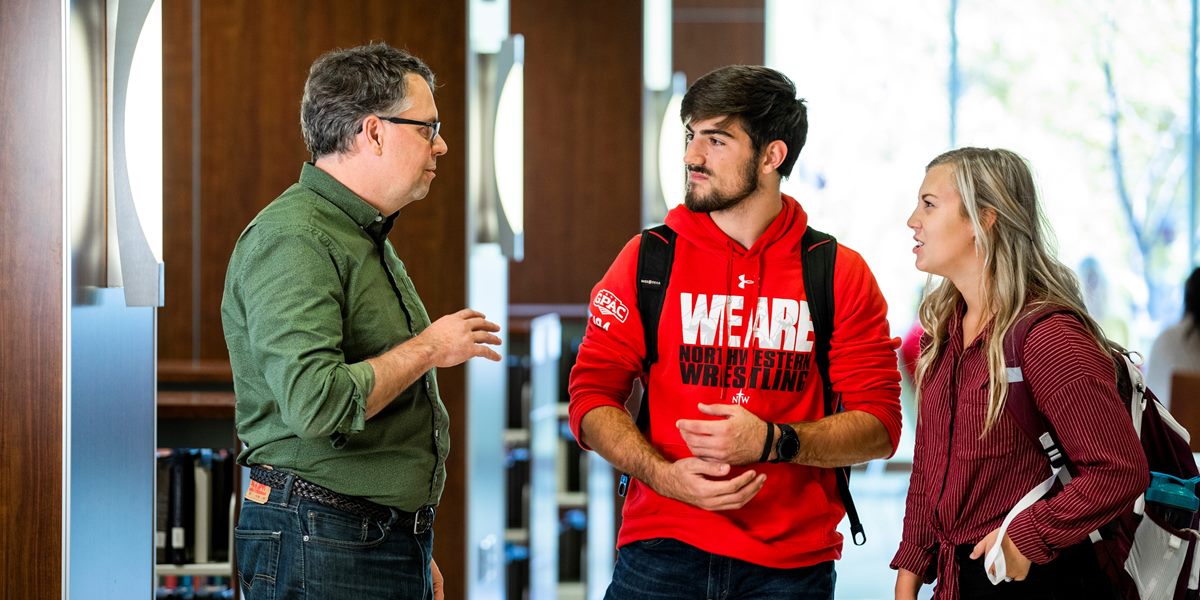 A Northwestern professor talks with students in the DeWitt Learning Commons.