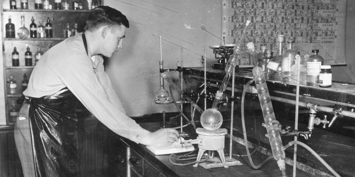 A student works in a 1960s biology lab.